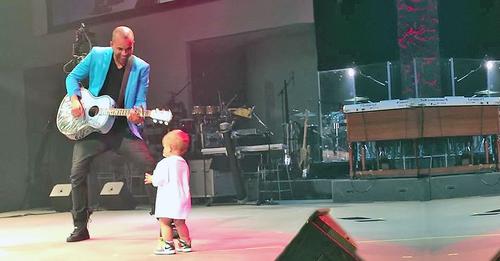 The baby came on stage to hug his daddy. At the 27th second he did something that made the audience squeal!